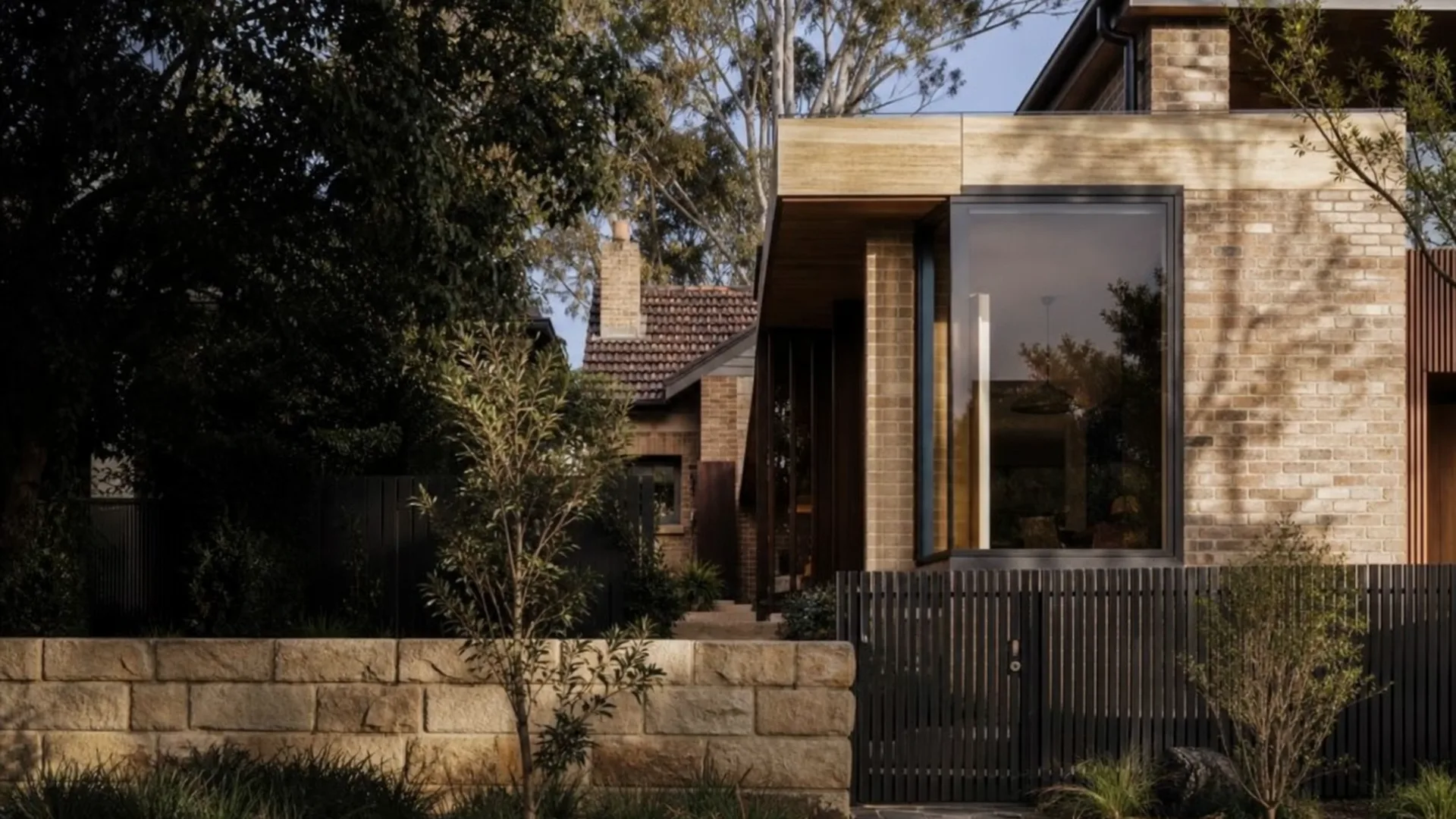 Concept visualisation — dusk approach to a finished brick Sydney home, warm interior light behind the glazing