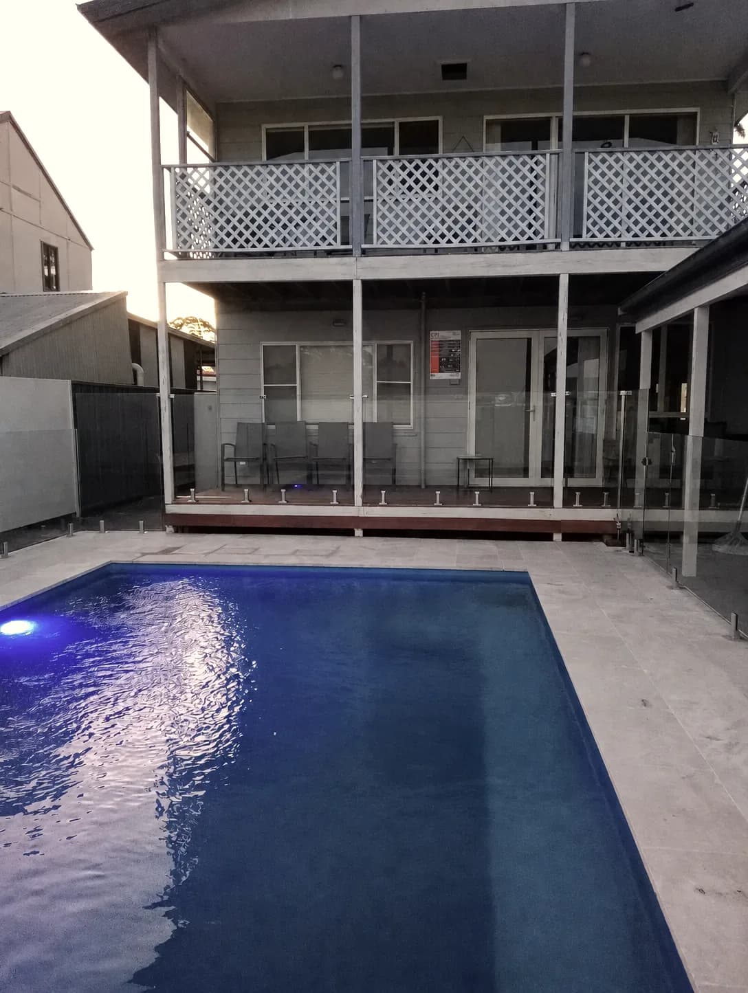 Greenwell — The pool at dusk with the dwelling lit behind