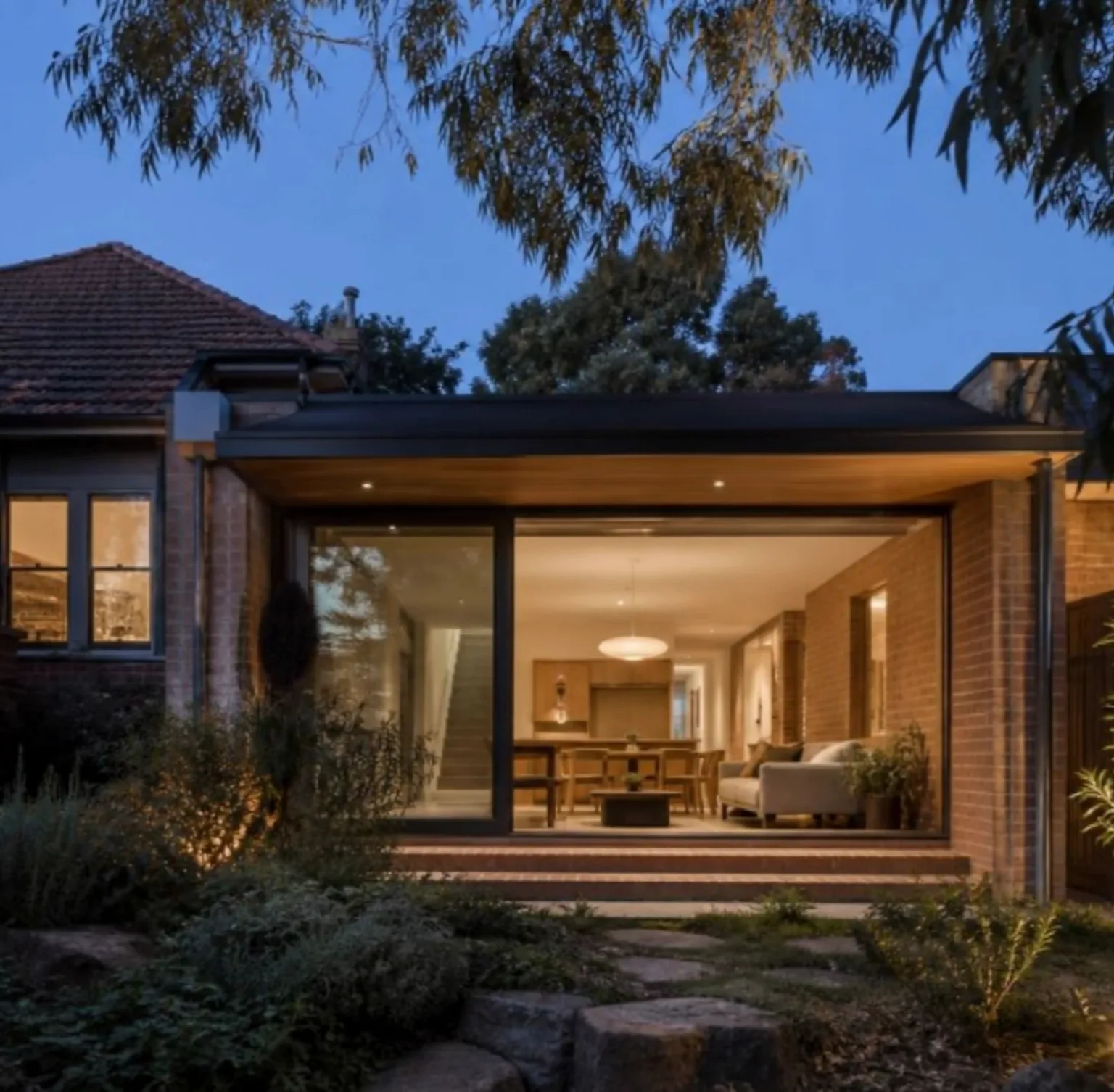 Concept visualisation — a single-storey extension with full-height glazing at dusk