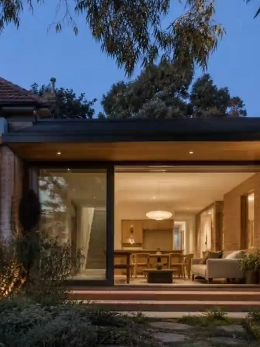 Concept visualisation — the frontage of a completed brick and timber home at dusk