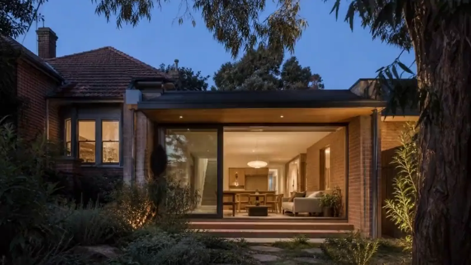 Concept visualisation — the frontage of a completed brick and timber home at dusk