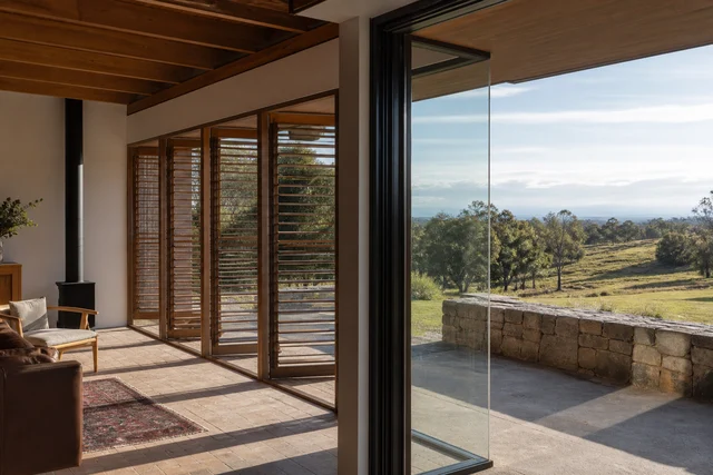 Deep eave shading a window beside insulated masonry and timber screening